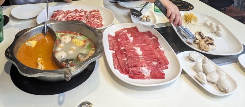 Photo of Hot Pot meal with boiling soup and meats and veggies on the side